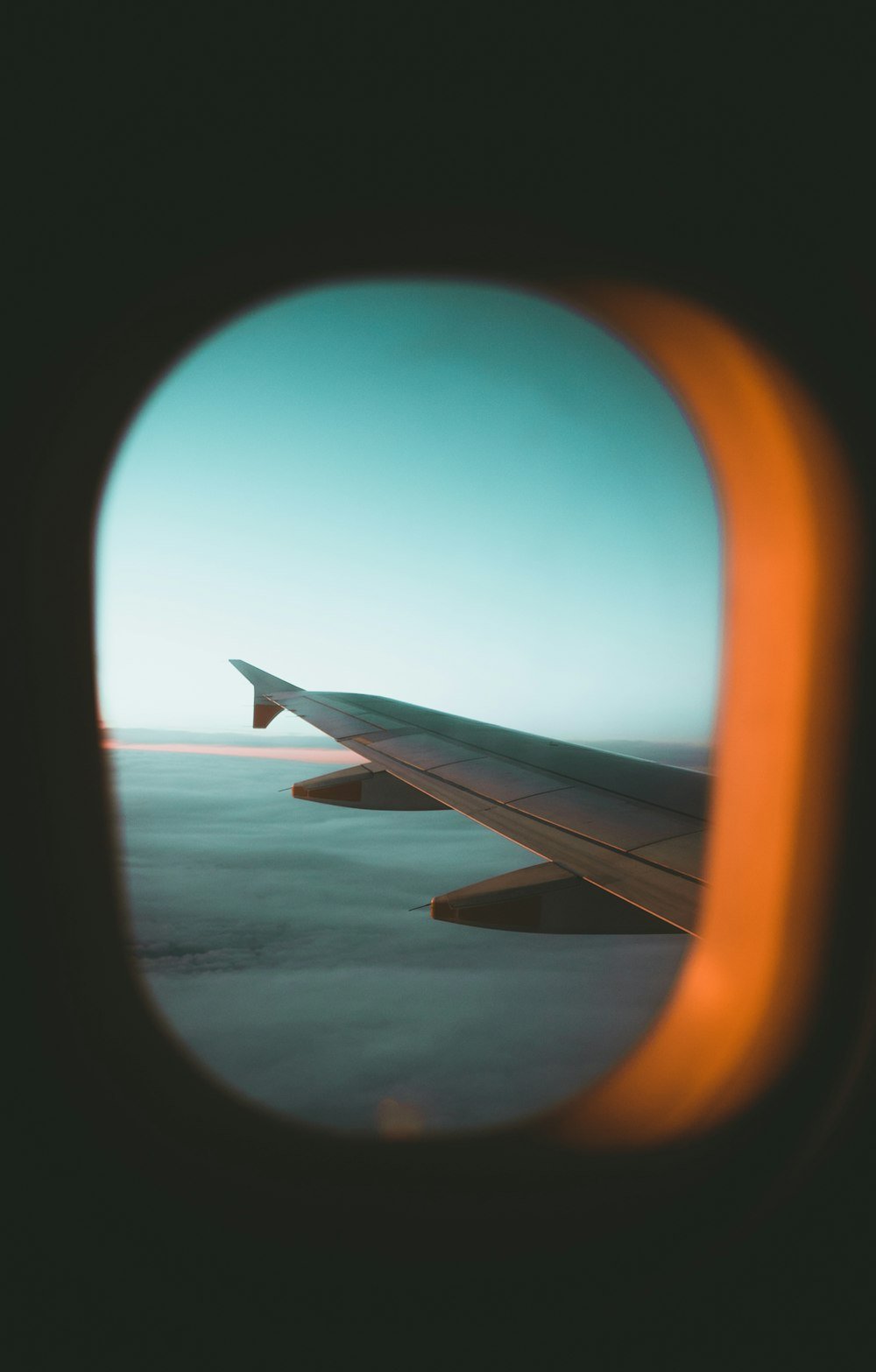 Vista da janela do avião com a asa e o céu ao amanhecer
