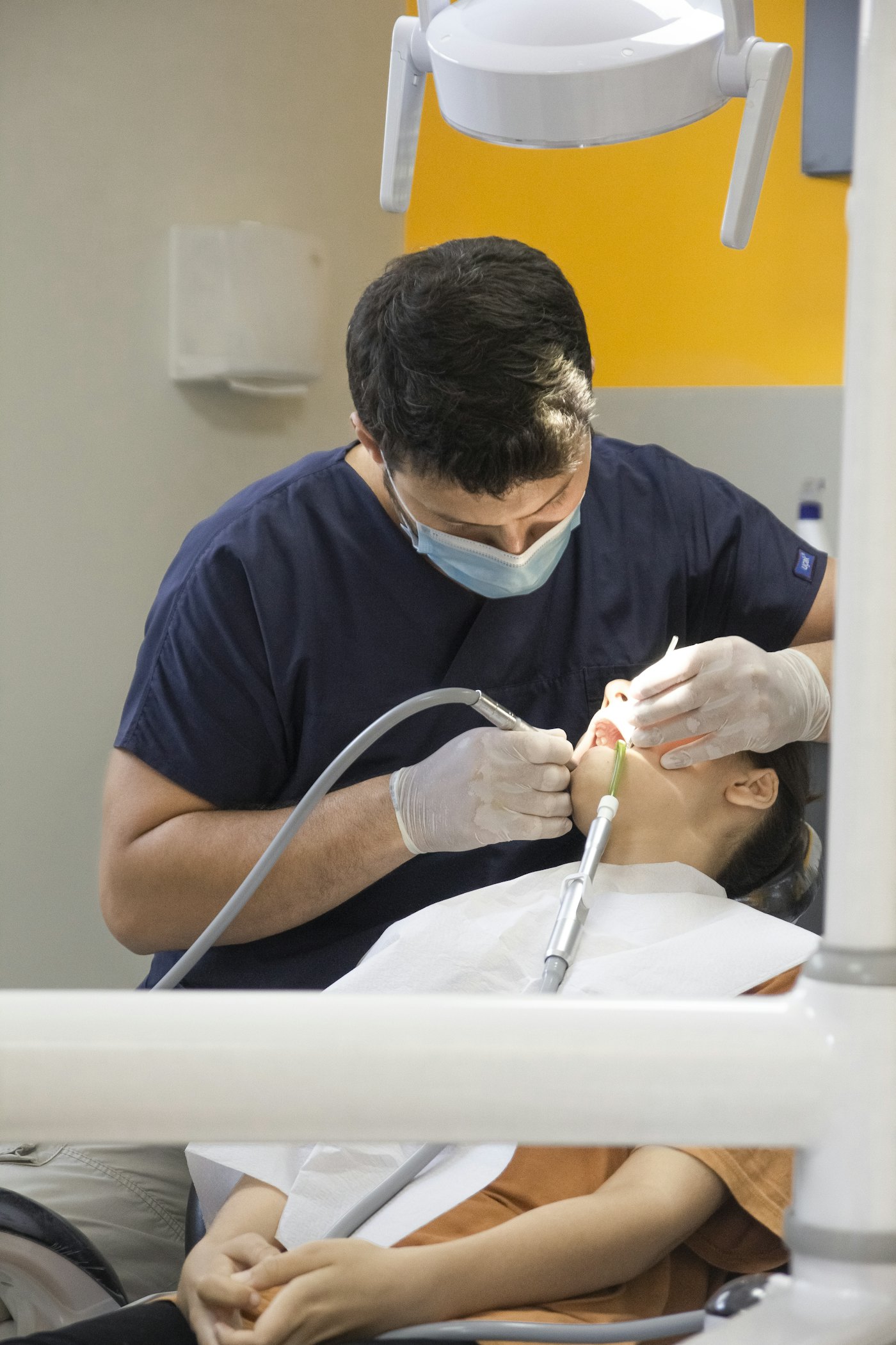 Profissional de odontologia atendendo paciente em consultório